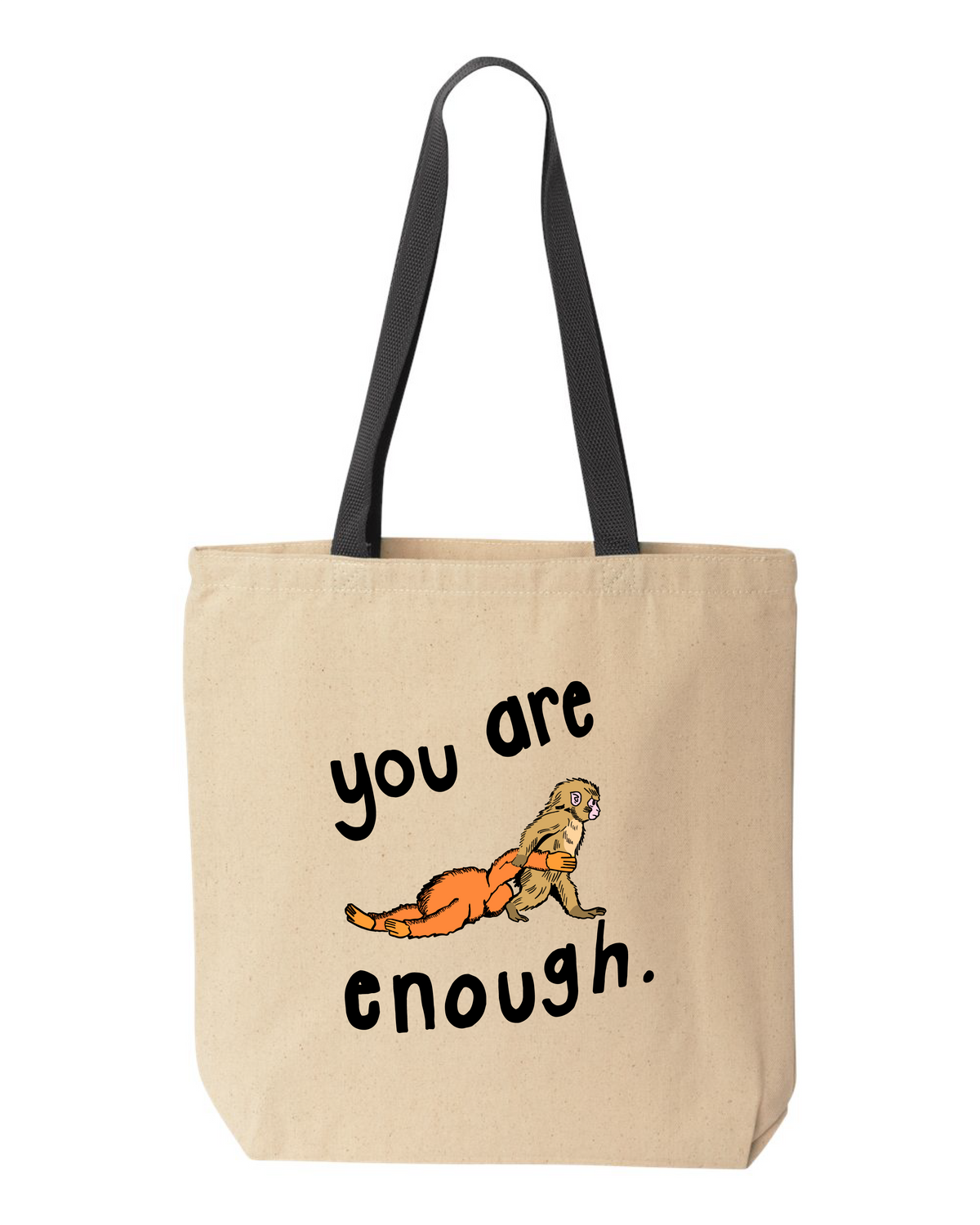 Natural canvas tote bag with black handles, printed with a small monkey holding an orange stuffed animal and the words you are enough