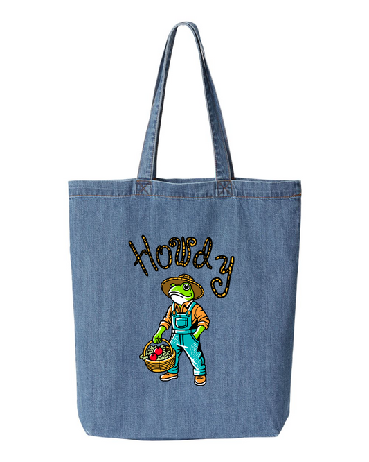 Denim tote bag printed with a frog in a straw hat and overalls holding a basket of produce, under the word howdy