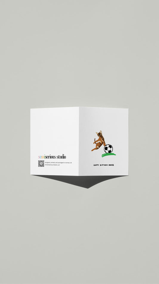 Aries Cat Birthday card standing open, showing the front artwork and the Semiserious Studio logo on the back