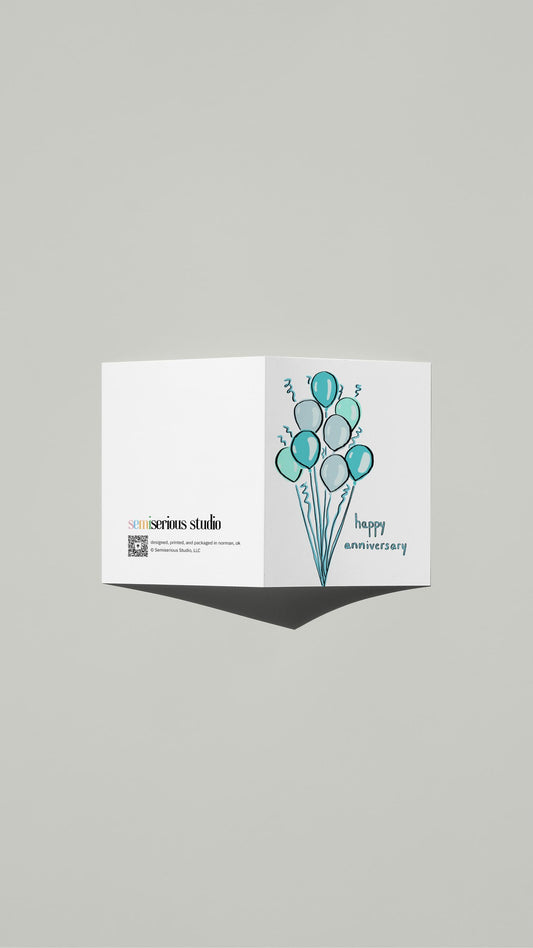 Blue Balloons Anniversary card standing open, showing the front artwork and the Semiserious Studio logo on the back