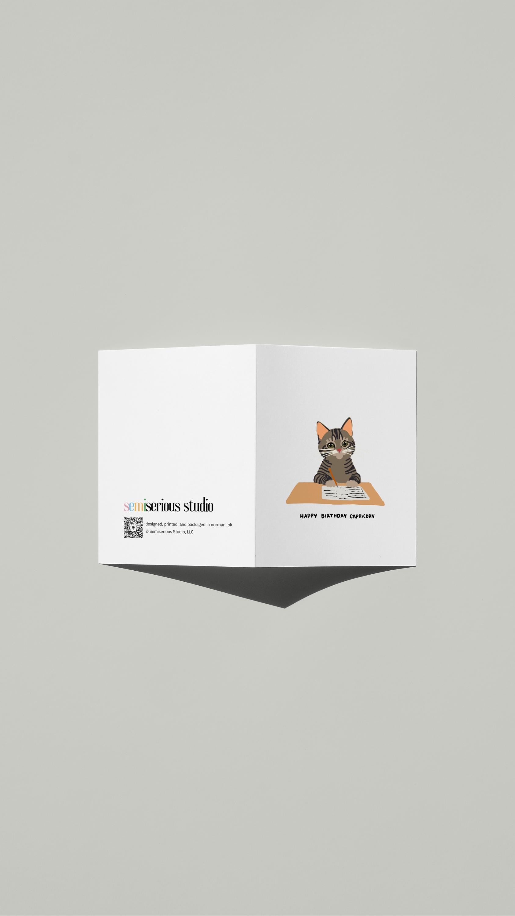 Capricorn Cat To-Do List Birthday card standing open, showing the front artwork and the Semiserious Studio logo on the back