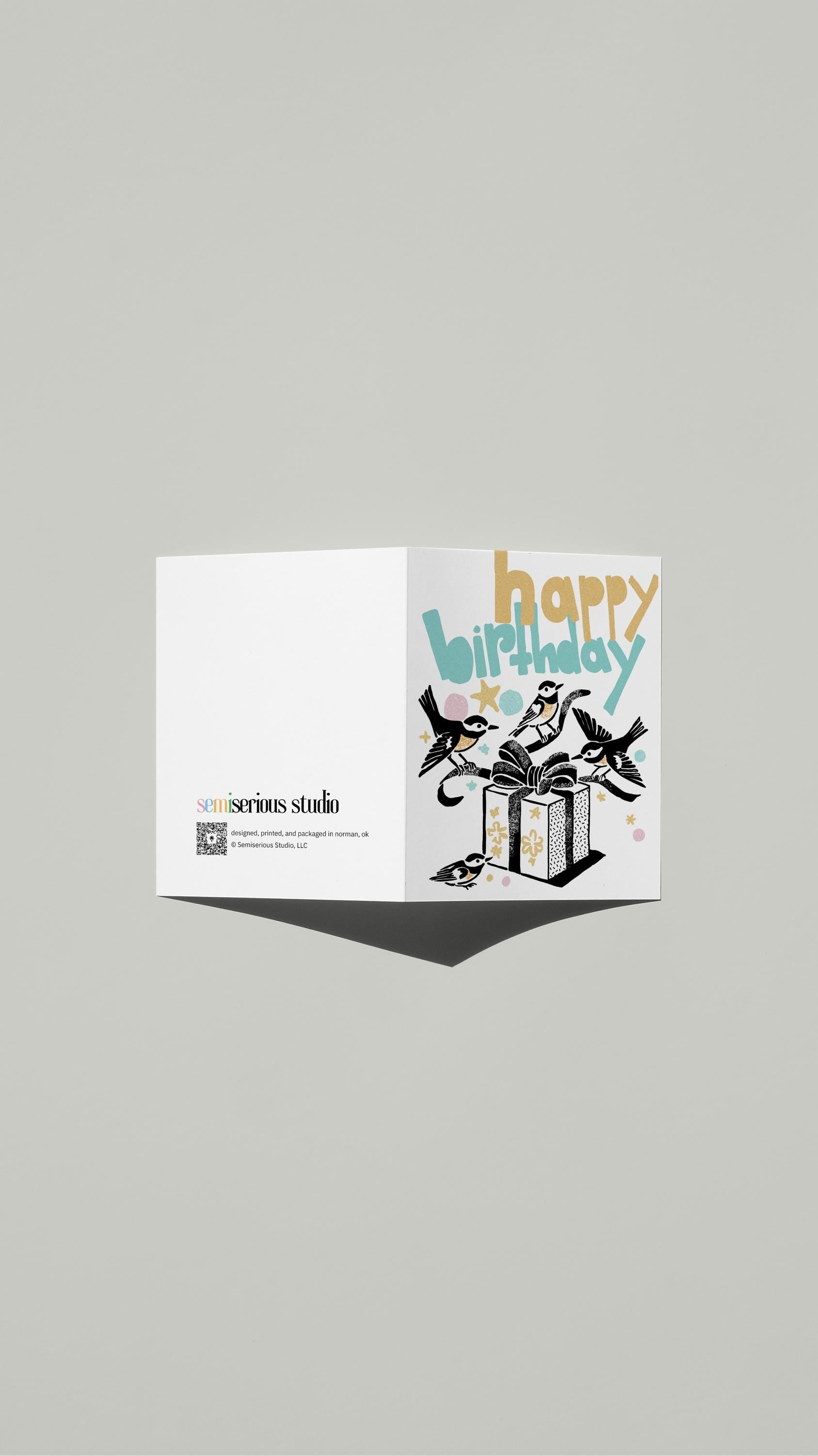 Colorful Birds Birthday card standing open, showing the front artwork and the Semiserious Studio logo on the back