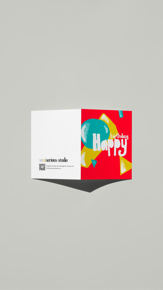 Colorful Happy Birthday card standing open, showing the front artwork and the Semiserious Studio logo on the back