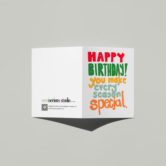 December Birthday Holiday card standing open, showing the front artwork and the Semiserious Studio logo on the back