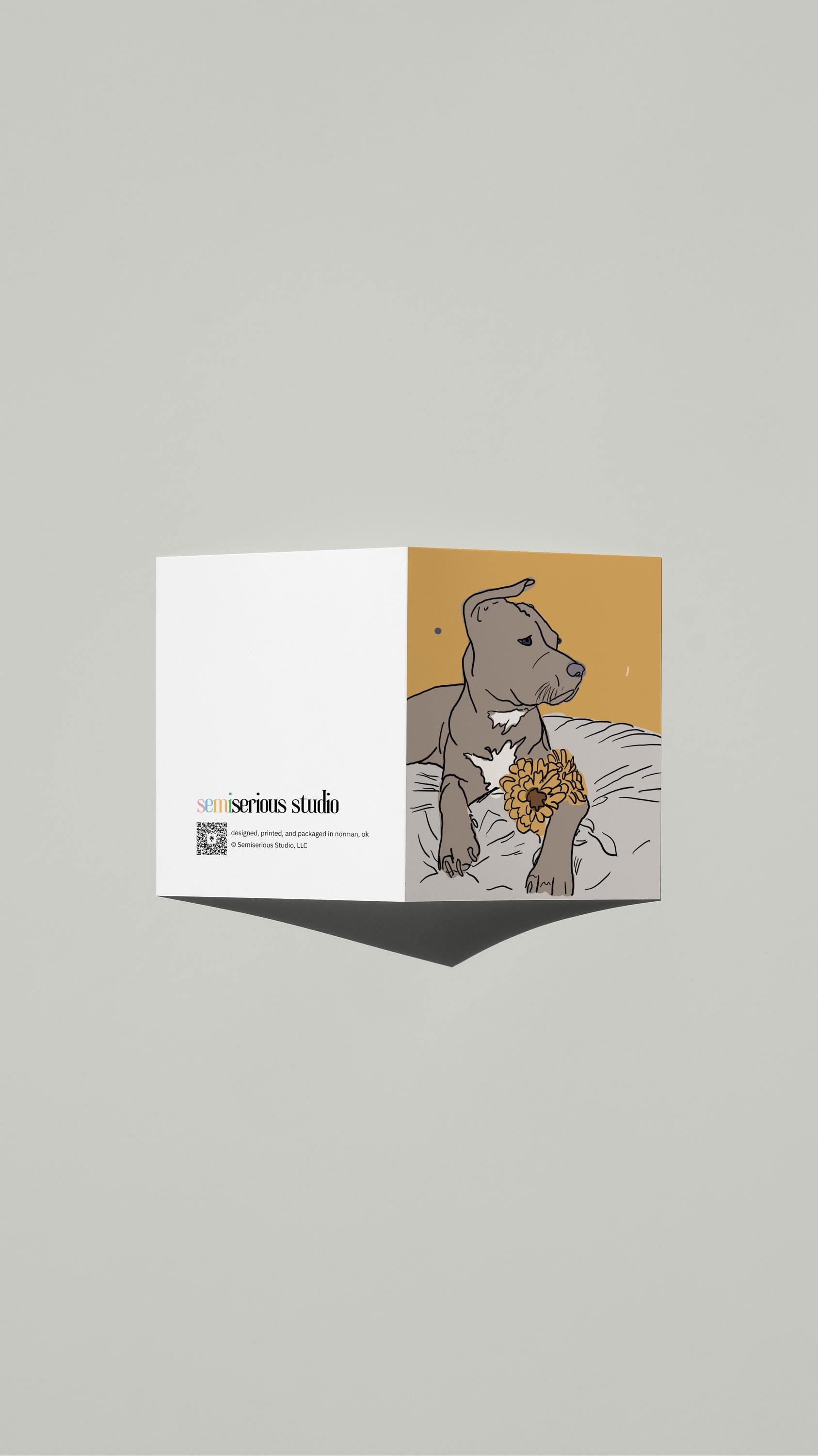 Dog with Flowers Just Because card standing open, showing the front artwork and the Semiserious Studio logo on the back