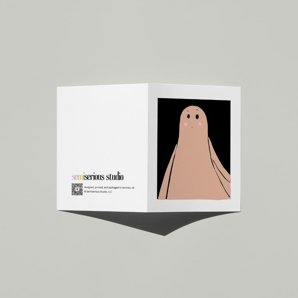 Ghost Costume Halloween card standing open, showing the front artwork and the Semiserious Studio logo on the back