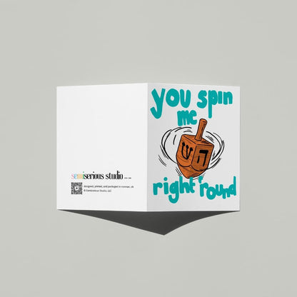 Hanukkah Dreidel card standing open, showing the front artwork and the Semiserious Studio logo on the back