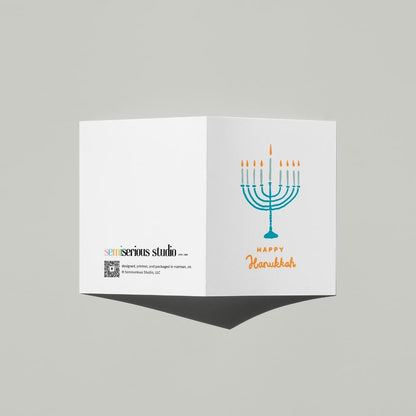 Happy Hanukkah Menorah card standing open, showing the front artwork and the Semiserious Studio logo on the back