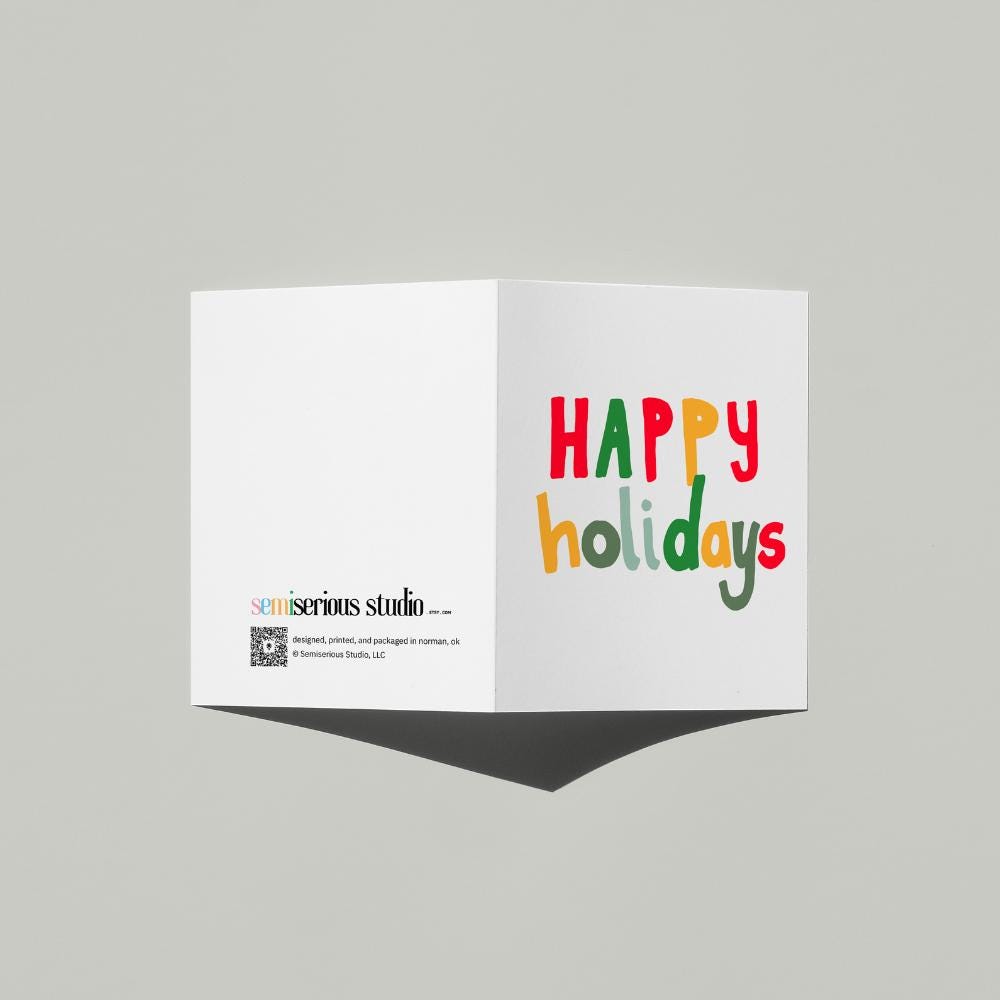 Happy Holidays card standing open, showing the front artwork and the Semiserious Studio logo on the back