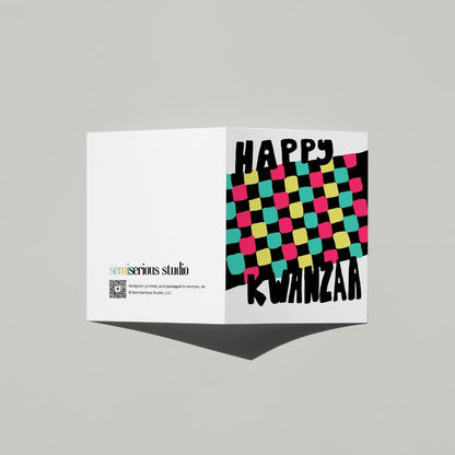 Happy Kwanzaa Mkeka card standing open, showing the front artwork and the Semiserious Studio logo on the back