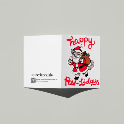 Happy Paw-lidays Cat Santa Christmas card standing open, showing the front artwork and the Semiserious Studio logo on the