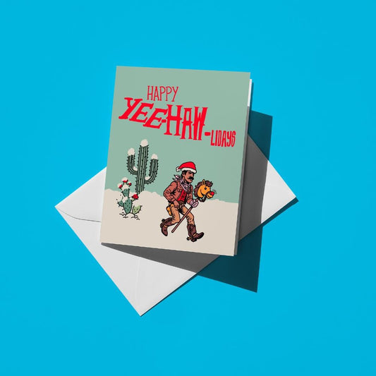 Cowboy in a Santa hat with a horse and cactus, reading "Happy yeehaw-lidays"