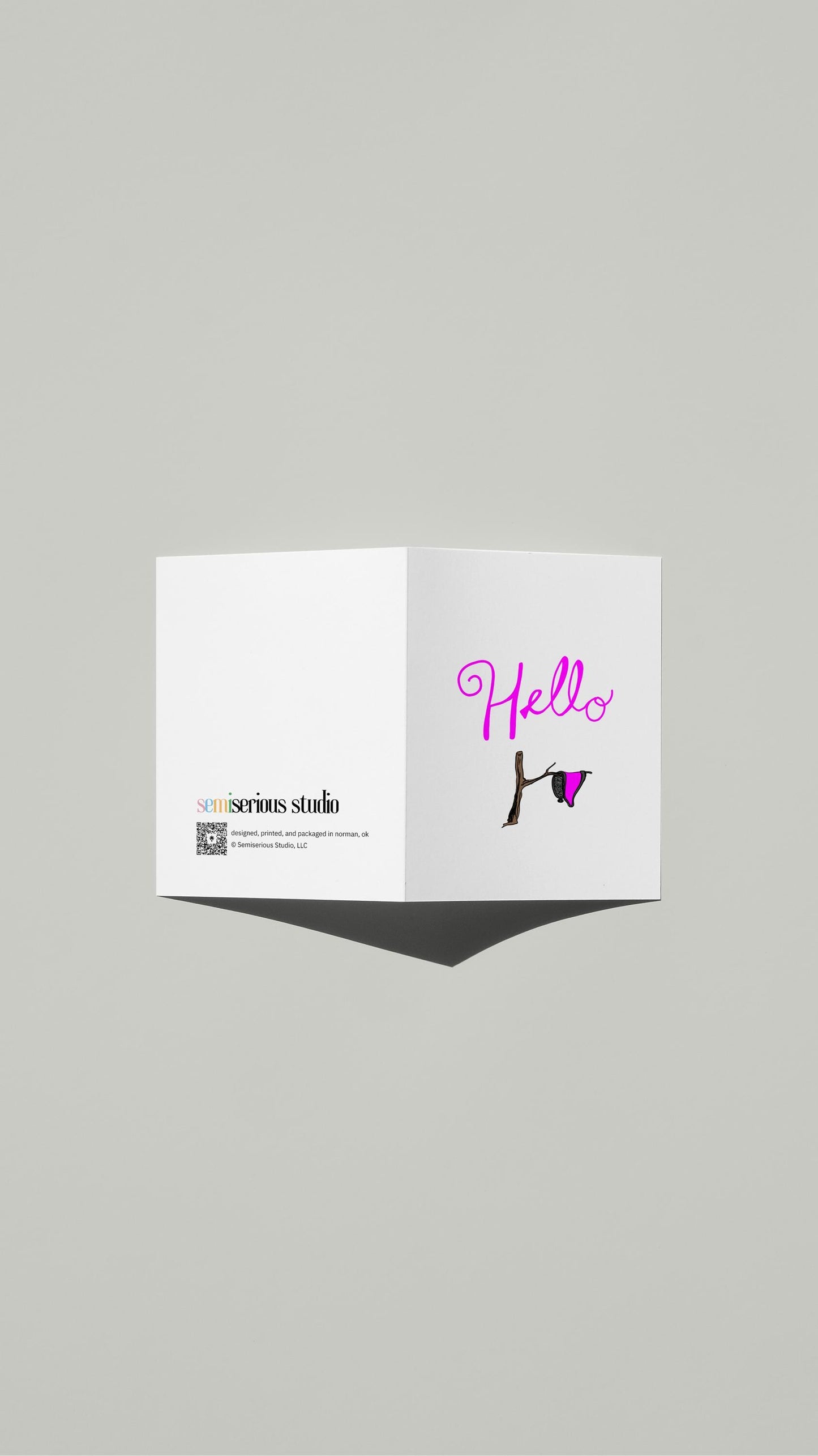 Hello Dali Pun card standing open, showing the front artwork and the Semiserious Studio logo on the back
