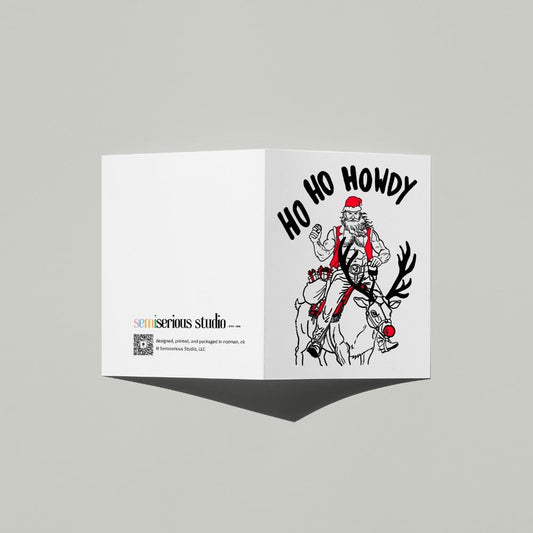 Ho Ho Howdy Cowboy Santa Christmas card standing open, showing the front artwork and the Semiserious Studio logo on the back