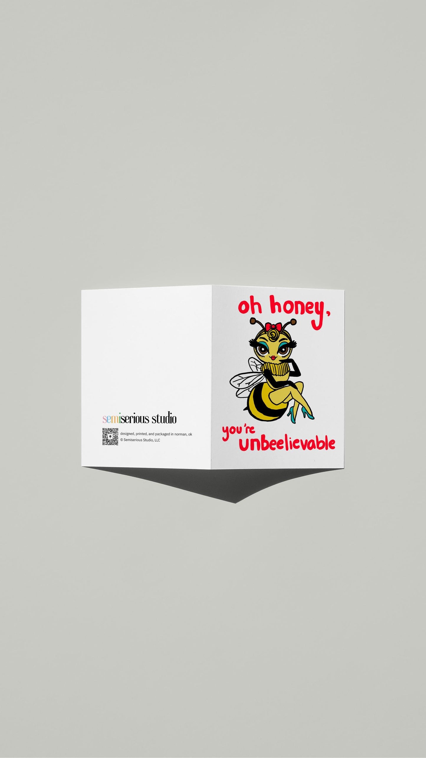 Honeybee Un-bee-lievable card standing open, showing the front artwork and the Semiserious Studio logo on the back