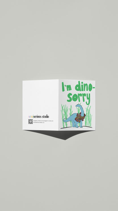 I'm Dino-Sorry Apology card standing open, showing the front artwork and the Semiserious Studio logo on the back