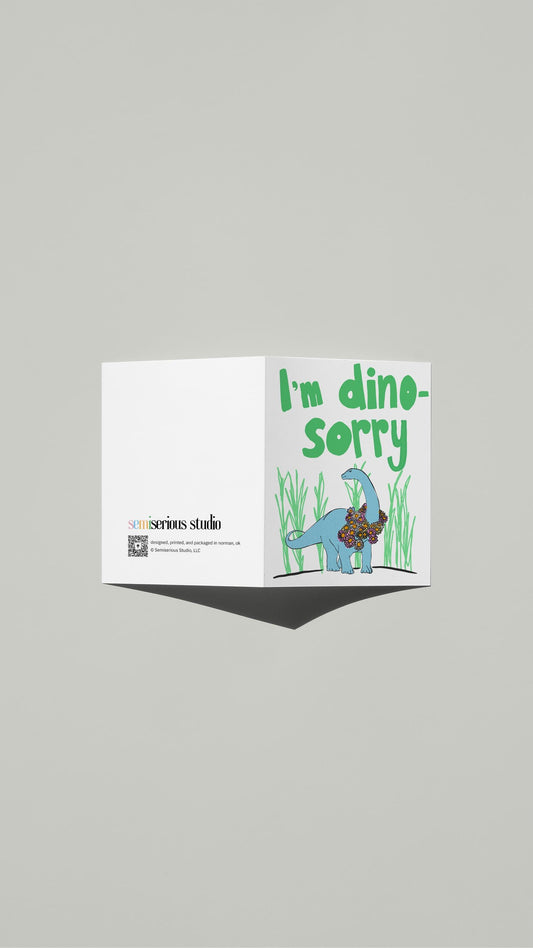 I'm Dino-Sorry Apology card standing open, showing the front artwork and the Semiserious Studio logo on the back