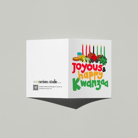 Joyous Happy Kwanzaa card standing open, showing the front artwork and the Semiserious Studio logo on the back