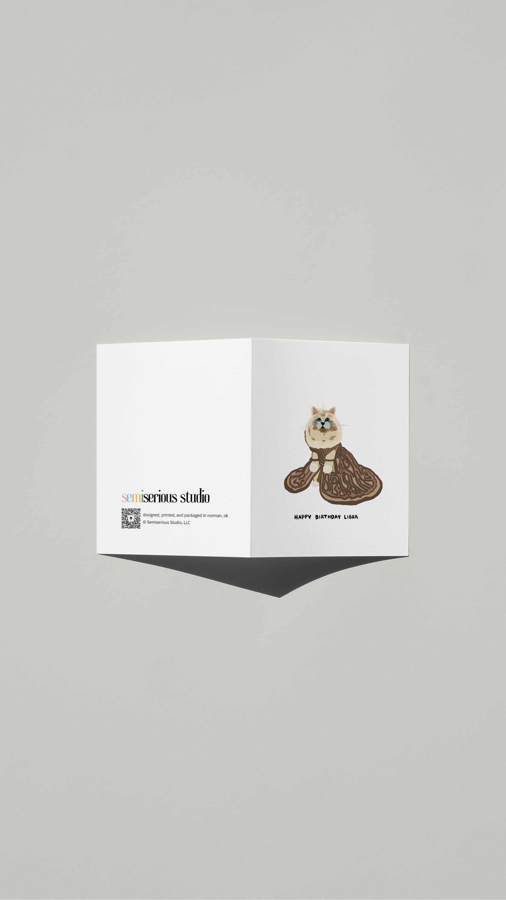 Libra Cat in Regal Gown Birthday card standing open, showing the front artwork and the Semiserious Studio logo on the back