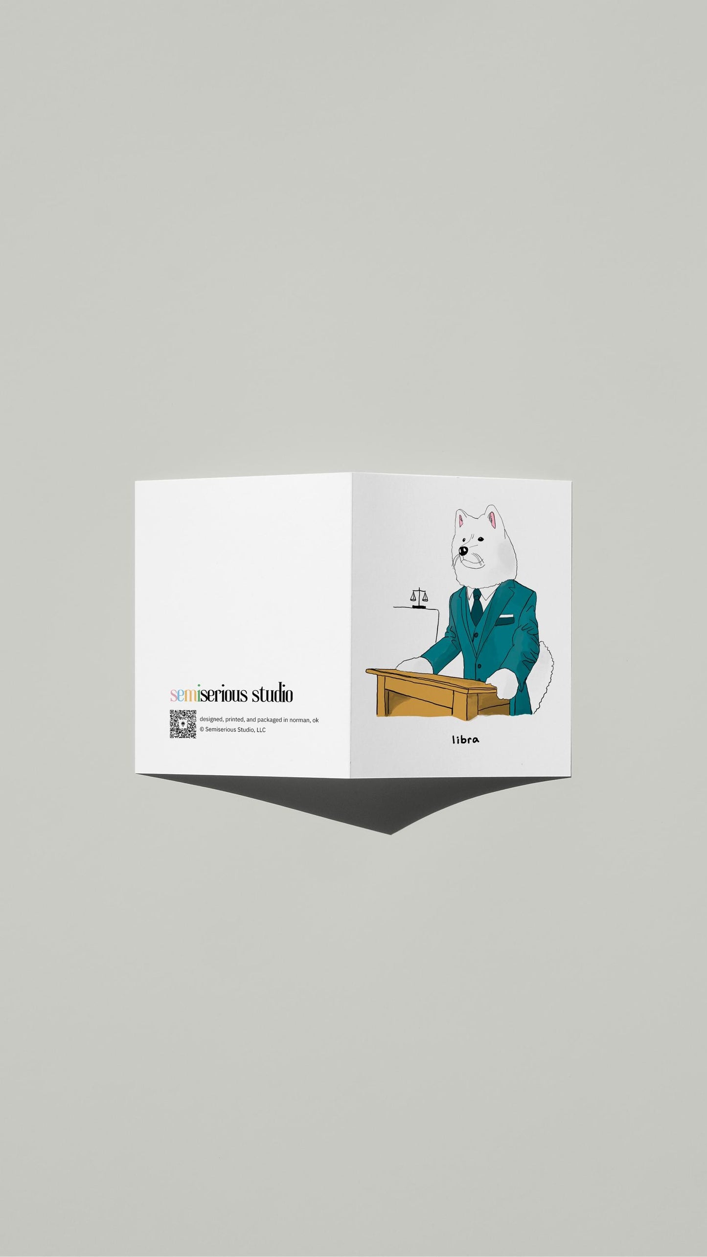Libra Samoyed Lawyer Birthday card standing open, showing the front artwork and the Semiserious Studio logo on the back