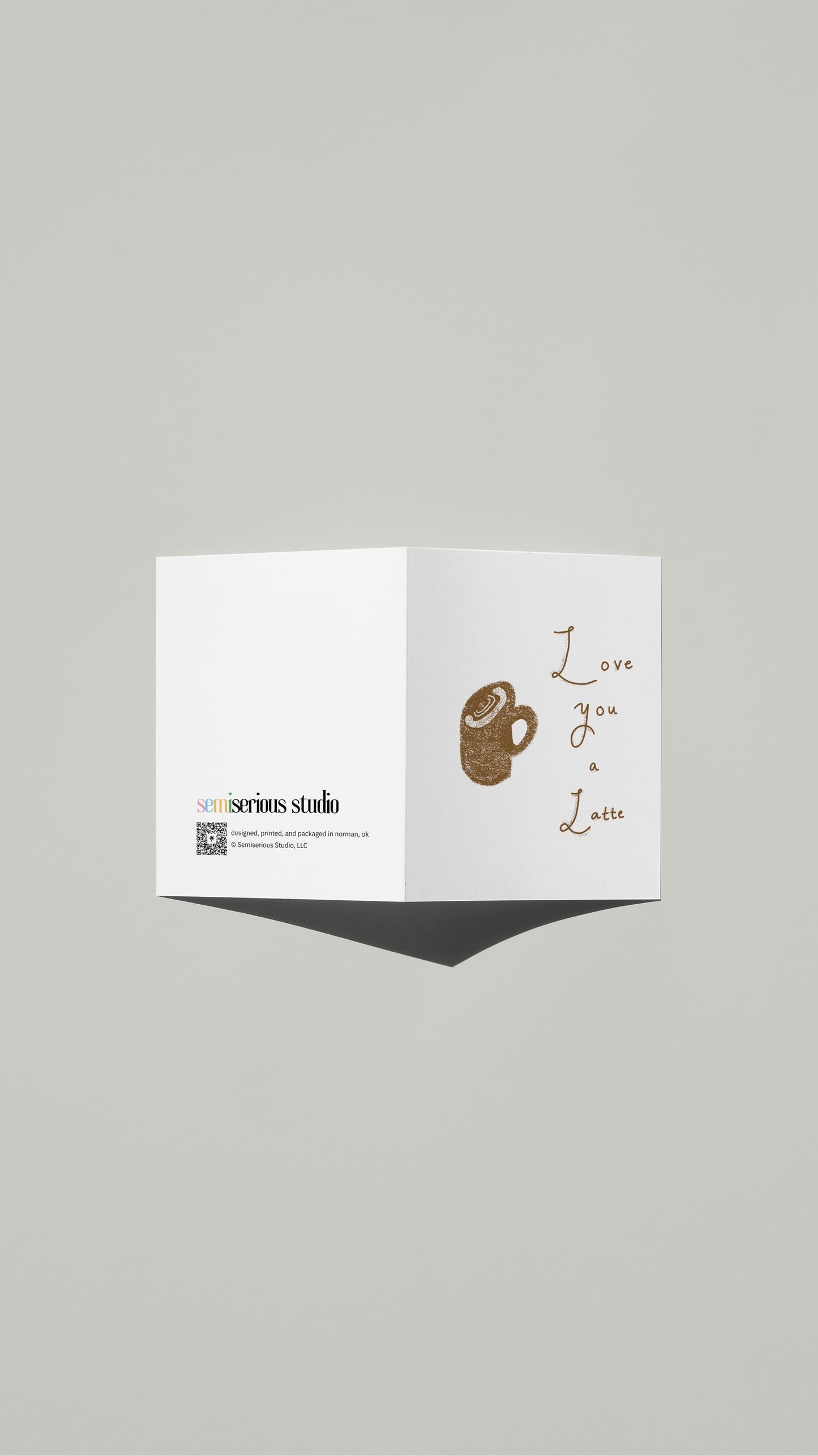 Love You a Latte Valentine card standing open, showing the front artwork and the Semiserious Studio logo on the back