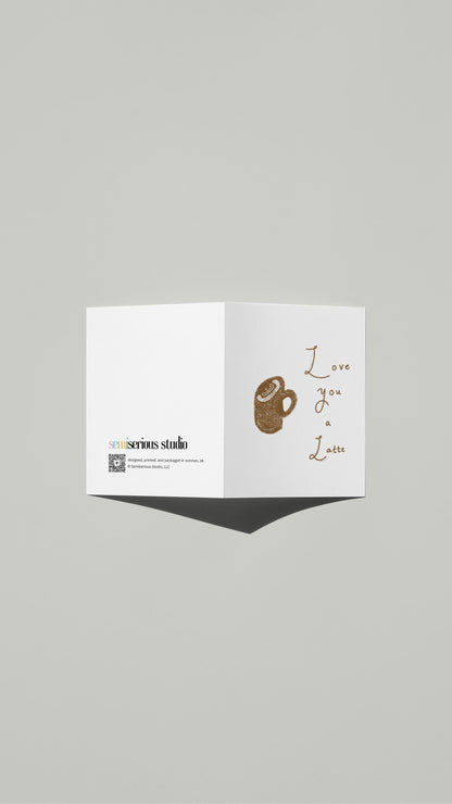 Love You a Latte Valentine card standing open, showing the front artwork and the Semiserious Studio logo on the back