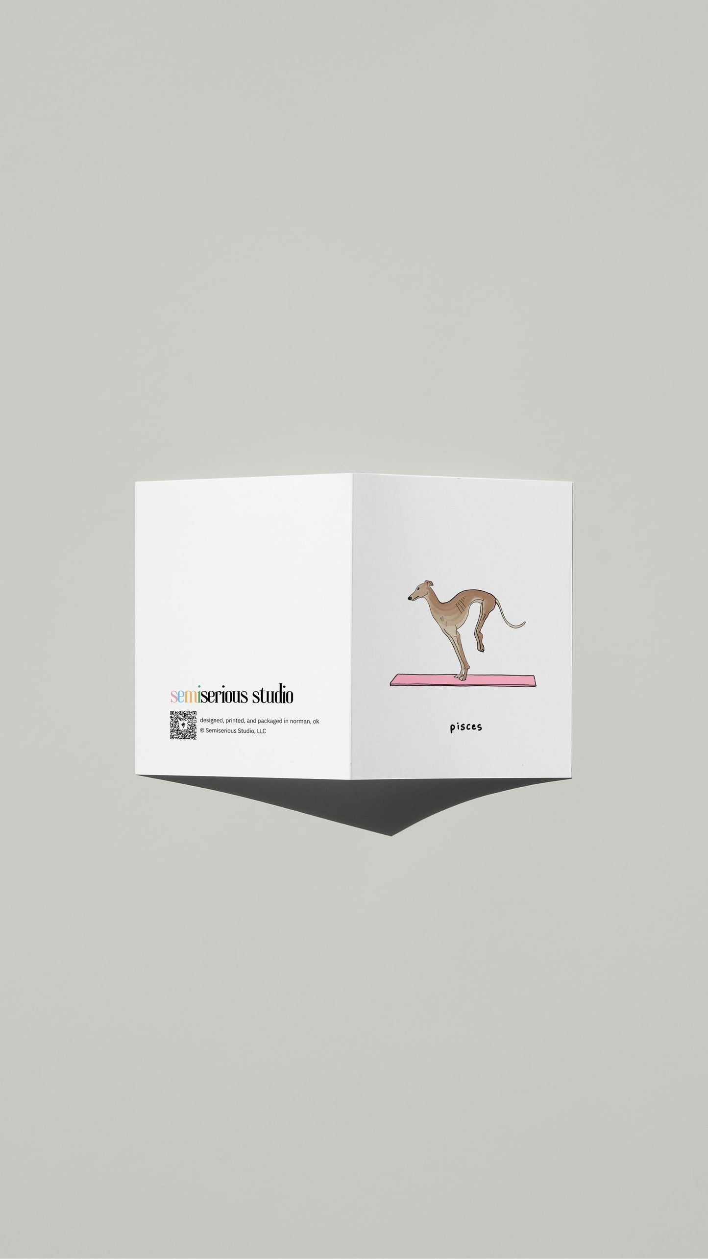 Pisces Dog Birthday card standing open, showing the front artwork and the Semiserious Studio logo on the back