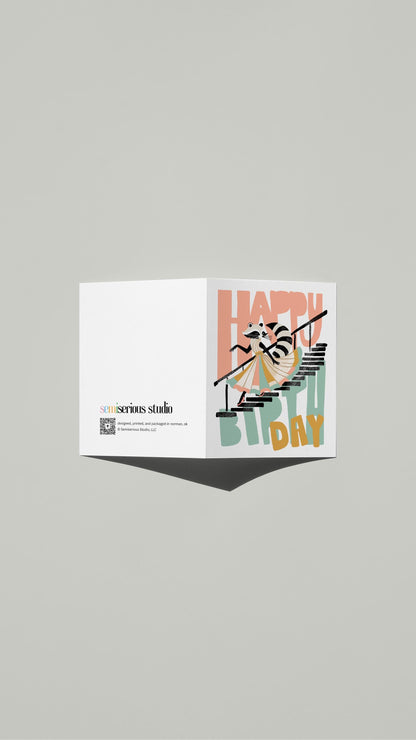 Raccoon Birthday card standing open, showing the front artwork and the Semiserious Studio logo on the back
