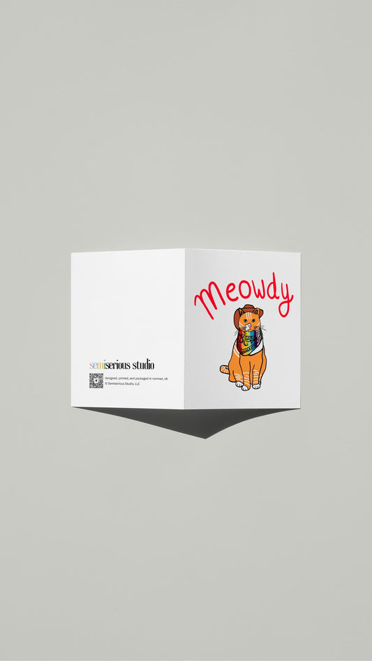 Rainbow Meowdy Cowboy Cat Pride card standing open, showing the front artwork and the Semiserious Studio logo on the back