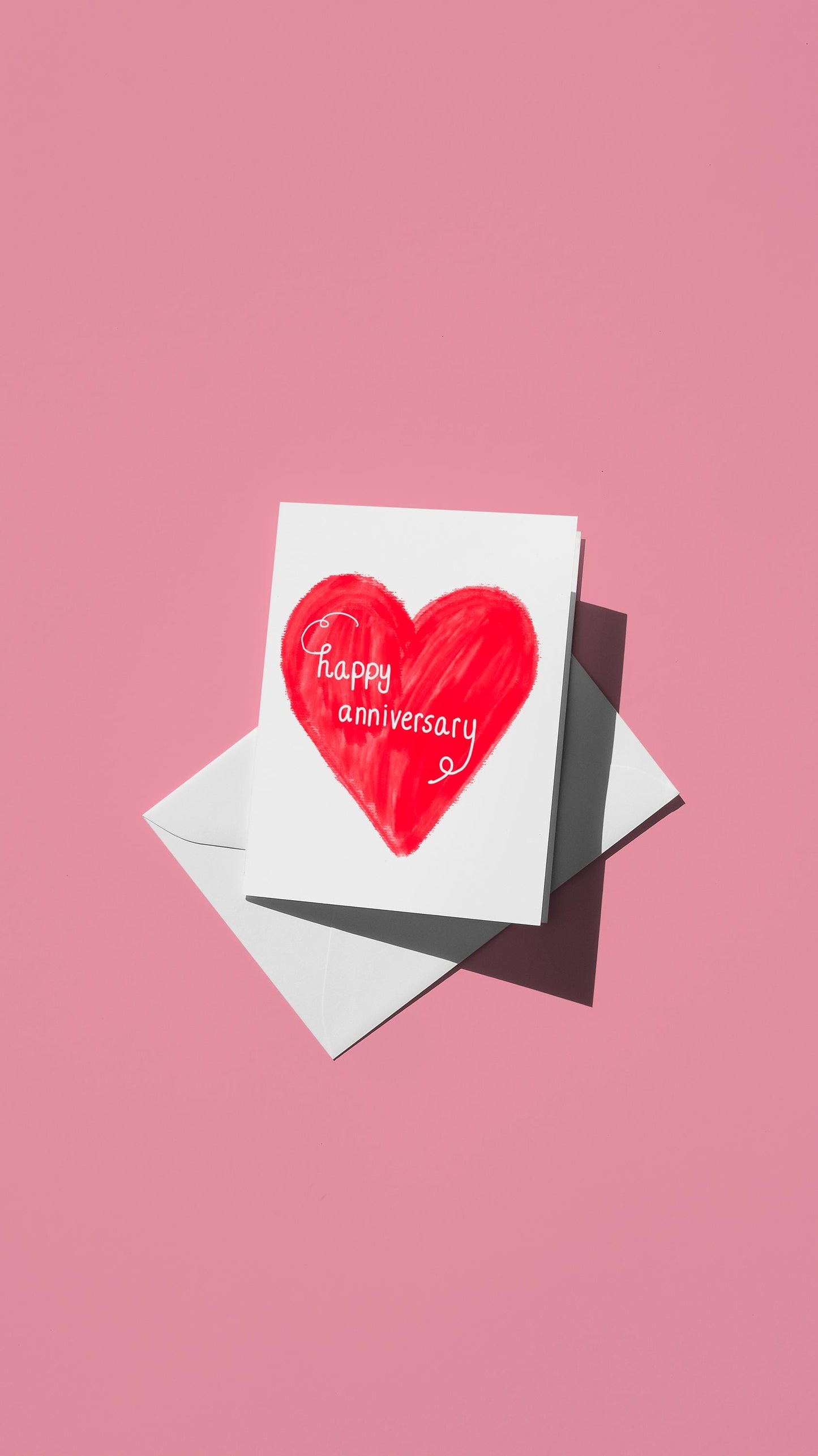 Hand-drawn illustration of a red heart with the message "happy anniversary" in a white script font
