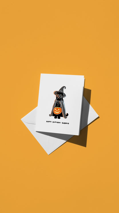 Hand-drawn illustration of a black tabby cat trick or treating in a witch costume for Halloween with the message "HAPPY