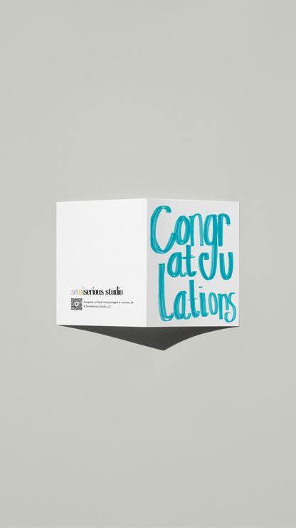 Simple Blue Congratulations card standing open, showing the front artwork and the Semiserious Studio logo on the back