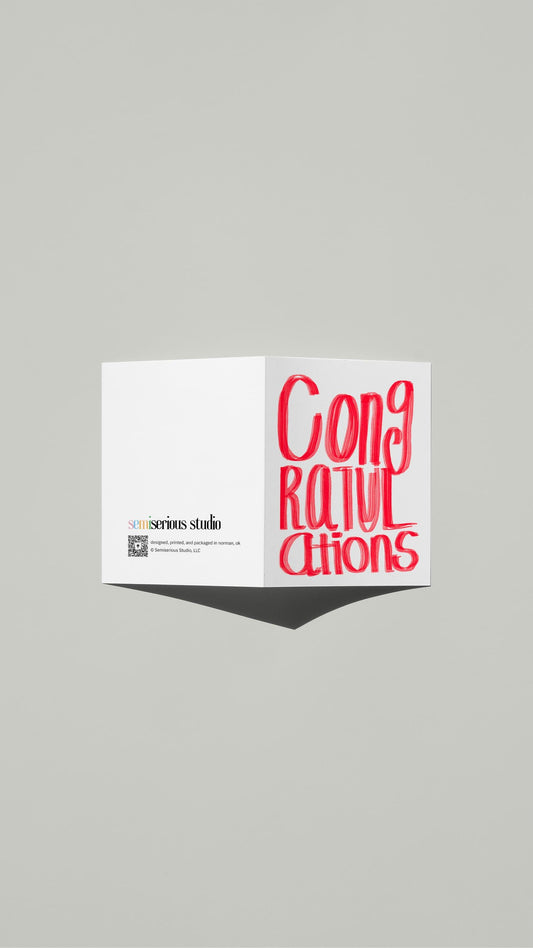 Simple Red Congratulations card standing open, showing the front artwork and the Semiserious Studio logo on the back