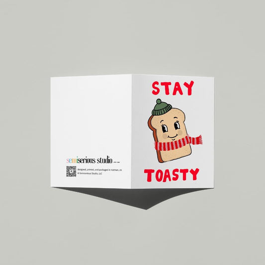 Stay Toasty Winter Holiday card standing open, showing the front artwork and the Semiserious Studio logo on the back