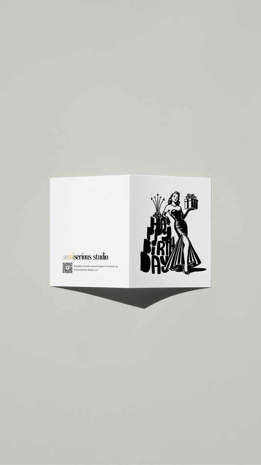Typography Cake Birthday card standing open, showing the front artwork and the Semiserious Studio logo on the back