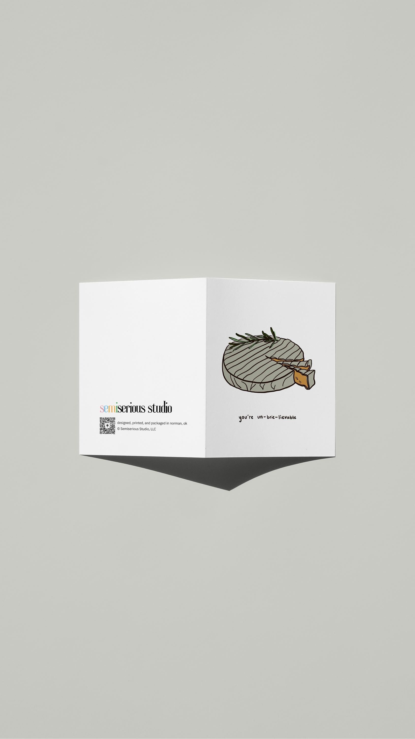 You're Un-Brie-Lievable Valentine card standing open, showing the front artwork and the Semiserious Studio logo on the back